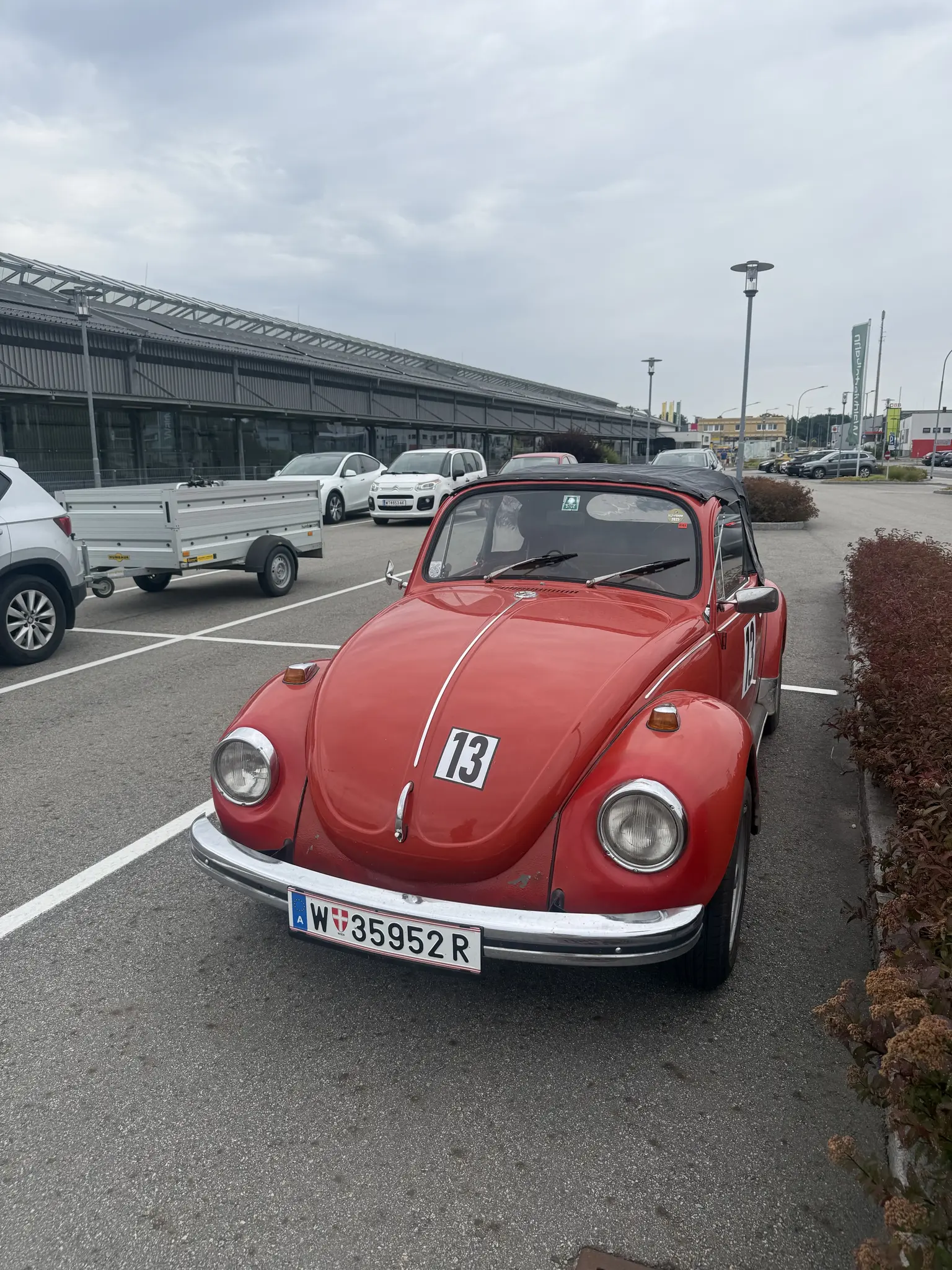 Roter VW Käfer 1302 auf einem Parkplatz neben der Waldviertelbahn in Gmünd. Cabrio-Umbau mit geschlossenen Dach