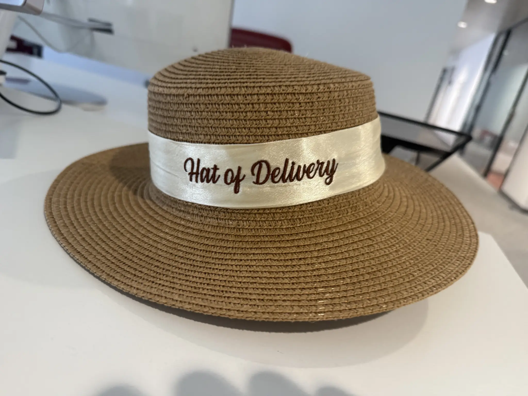 A brown woven head with a band saying „Hat of Delivery“ on an office table