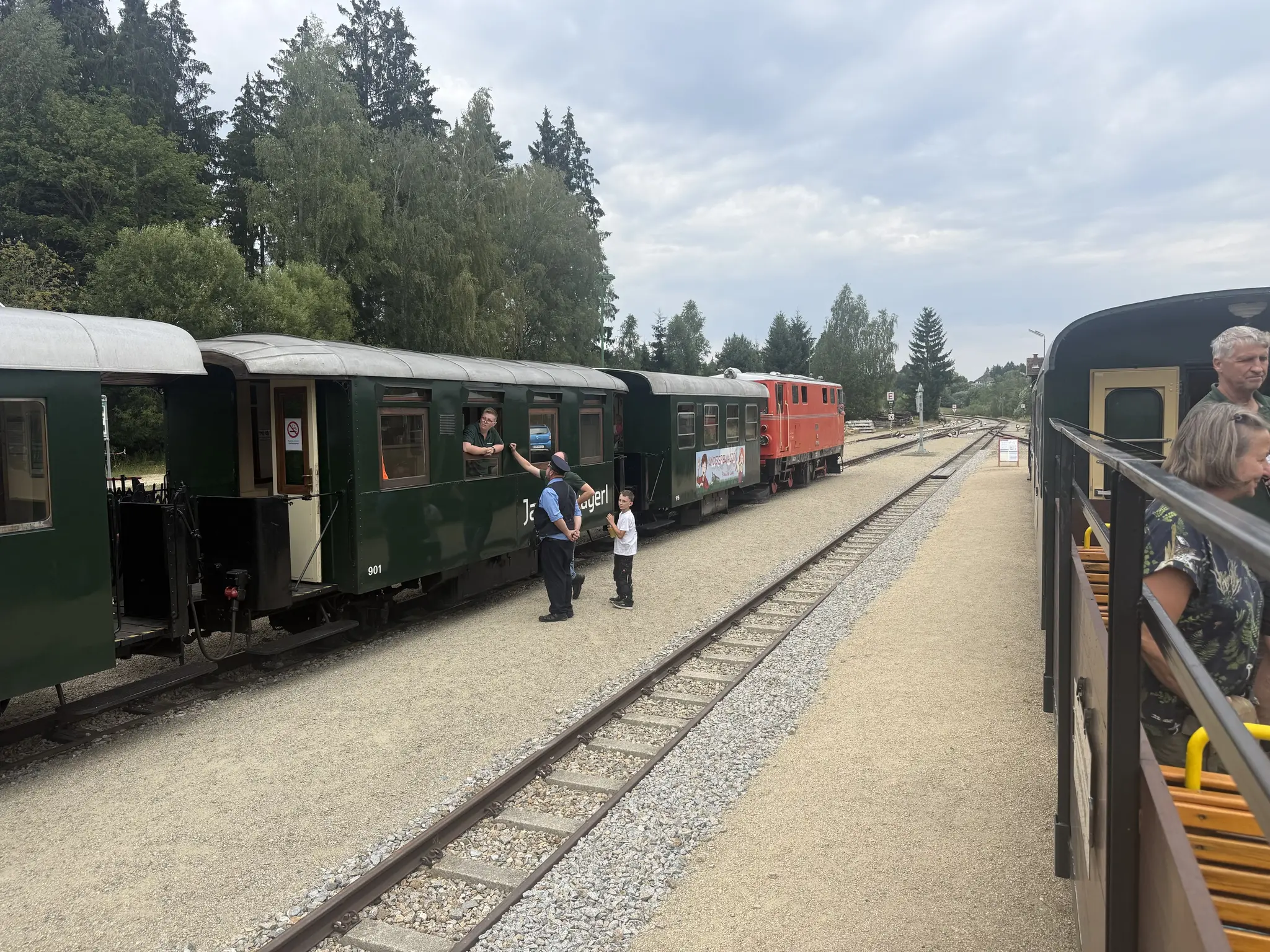 Zwei Schmalspurzüge in Alt-Nagelberg, dazwischen ein leeres gleis. Grüne Spantenwagen mit roter 2095 am Zug rechts. Das Foto wurde vom Cabrio-Wagen am rechren Zug gemacht